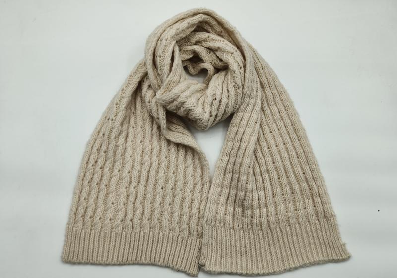 Cream beige cable knit scarf loosely knotted on white background, showing textured aran pattern and ribbed hem edges - ODM OEM service available - boutique retail bulk order