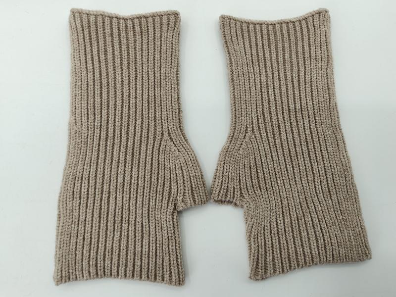 Pair of beige ribbed knit fingerless gloves laid flat on white background, showing thumb hole detail - air shipping 5-7 days arrival