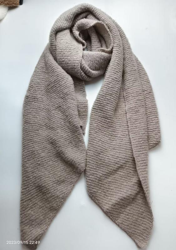 Beige taupe ribbed knit oversized scarf wrap laid flat on white surface, showing textured stripe pattern and generous length - WhatsApp quote in 2 hours