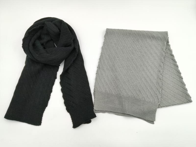 Two knit scarves flat lay: black draped scarf and folded light grey herringbone pattern scarf with ribbed edges on white background - air shipping 5-7 days arrival