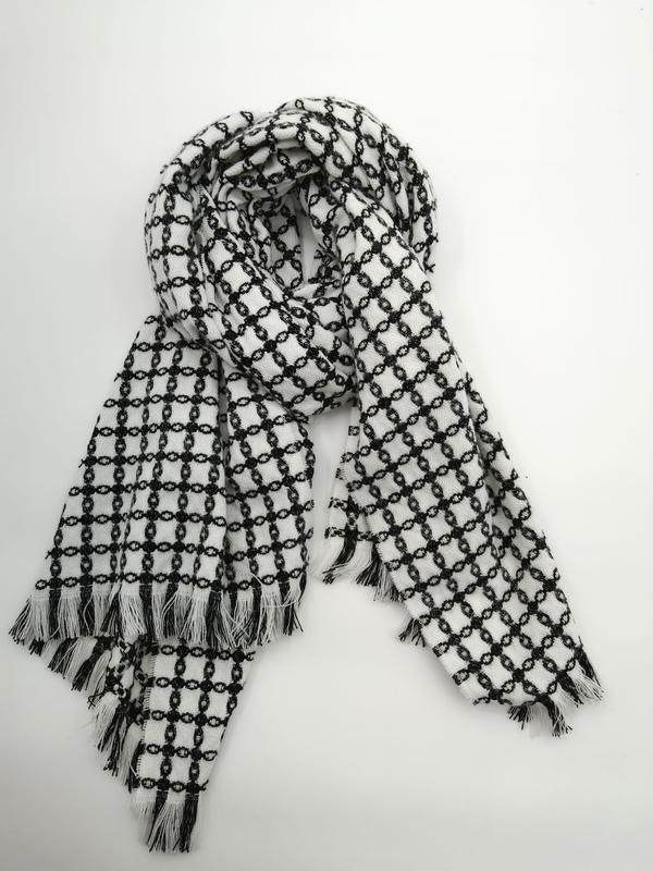 Black and white chain-link pattern woven scarf with fringe tassel ends, loosely draped on white background - retail buyer inquiry welcome