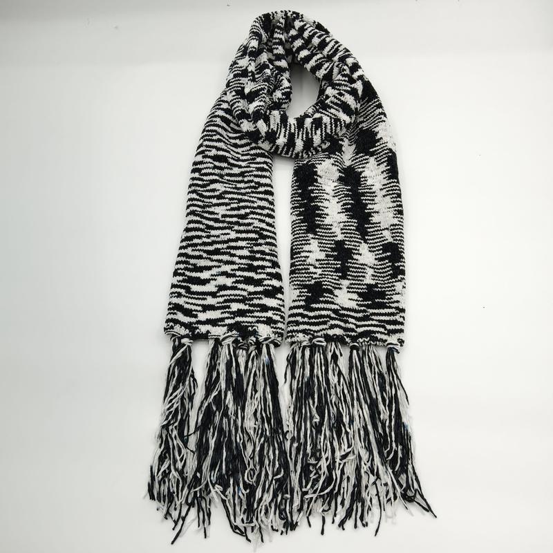 Black and white chunky knit scarf with zebra stripe pattern, bold graphic design, and long tassel fringe ends laid flat - jacquard custom pattern accepted