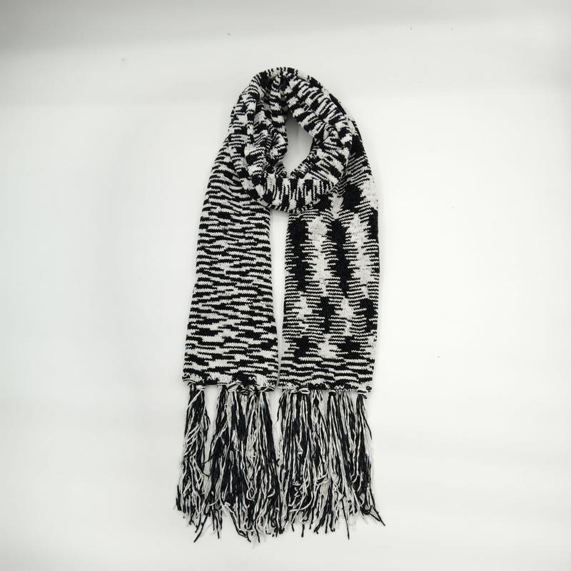 Black and white houndstooth patterned knit scarf with long mixed fringe tassels displayed folded on white background - custom packaging design free