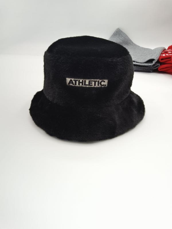 Black fluffy faux fur bucket hat with embroidered Athletic patch label, displayed on white surface with grey and red accessories - certified scarf manufacturer China - bulk order 500+ pcs extra 8% off