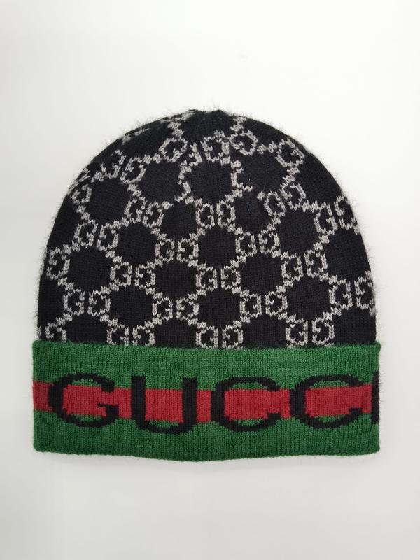 Black and grey interlocking monogram knit beanie hat with green and red striped cuff band on white background - private label service available