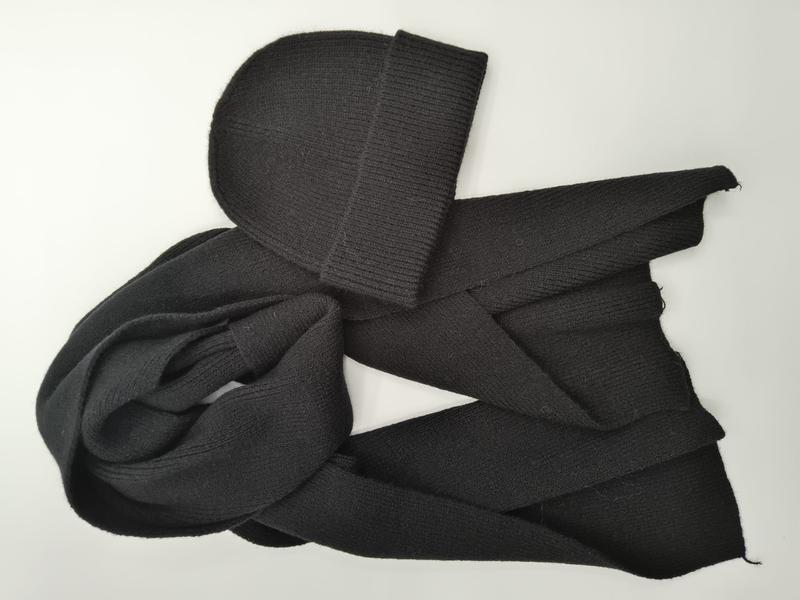 Black ribbed knit beanie hat paired with a long knitted scarf, laid flat on white background showing texture - custom logo label accepted