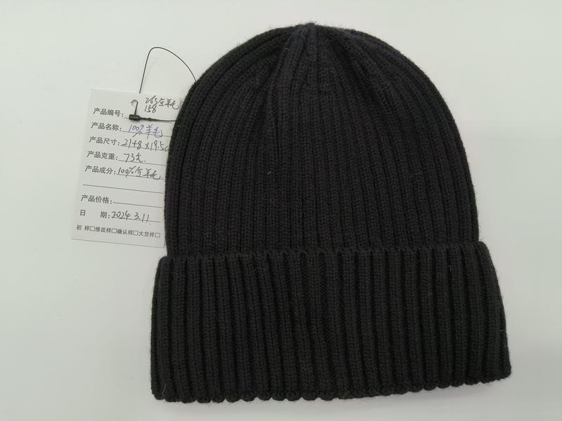 Black ribbed knit wool beanie hat with folded cuff displayed flat on white background with product tag - Oeko-Tex Standard 100 certified