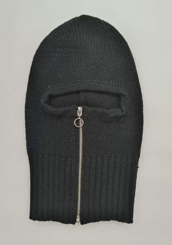 Black ribbed knit balaclava laid flat showing a silver zipper opening for the face area on a grey background - custom Pantone color matching