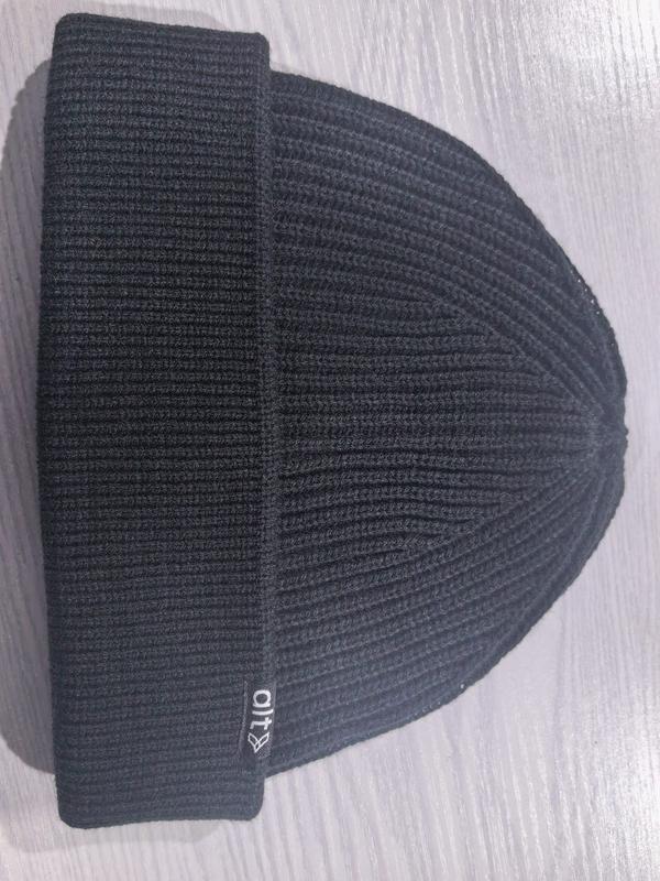 Black ribbed knit cuffed beanie hat laid flat on a light surface, showing textured knit pattern and folded brim - ODM OEM service available - air shipping 5-7 days arrival