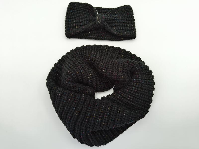 Black chunky knit infinity scarf coiled next to matching twist knot headband with multicolor metallic lurex threading - event merchandise supplier