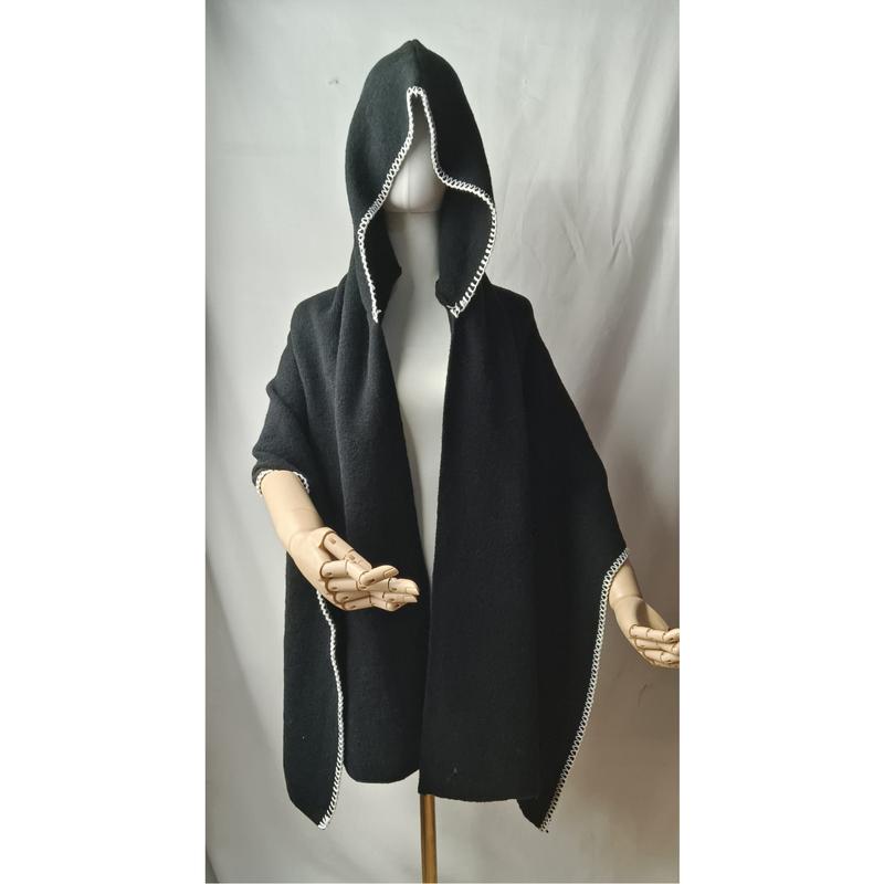 Black hooded poncho cape with white crochet border trim displayed on mannequin with wooden artist hands - low MOQ 50pcs trial order
