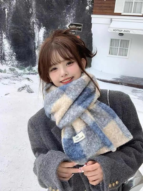 Young woman wearing a cozy blue and cream plaid oversized fluffy scarf in a snowy outdoor winter setting - Oeko-Tex Standard 100 certified