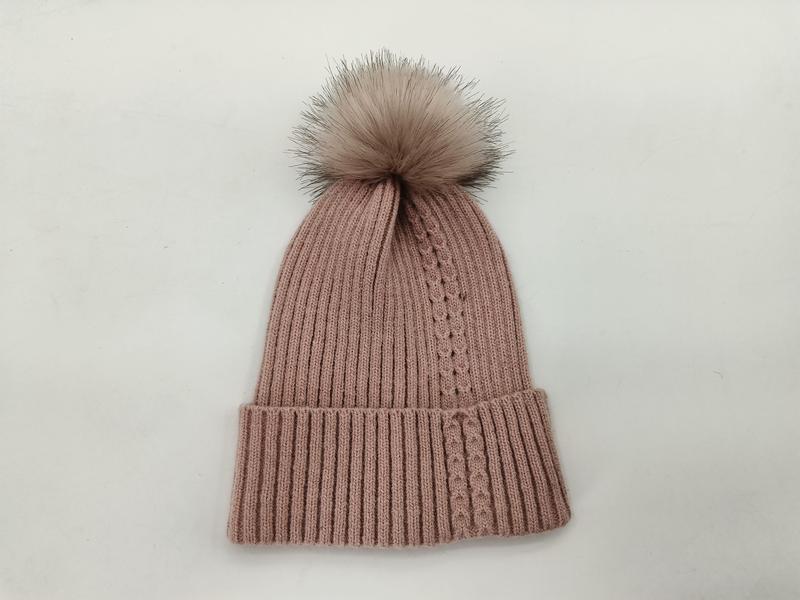 Blush pink ribbed knit winter beanie hat with large faux fur pom pom on white background - certified scarf manufacturer China - ISO 9001 quality controlled