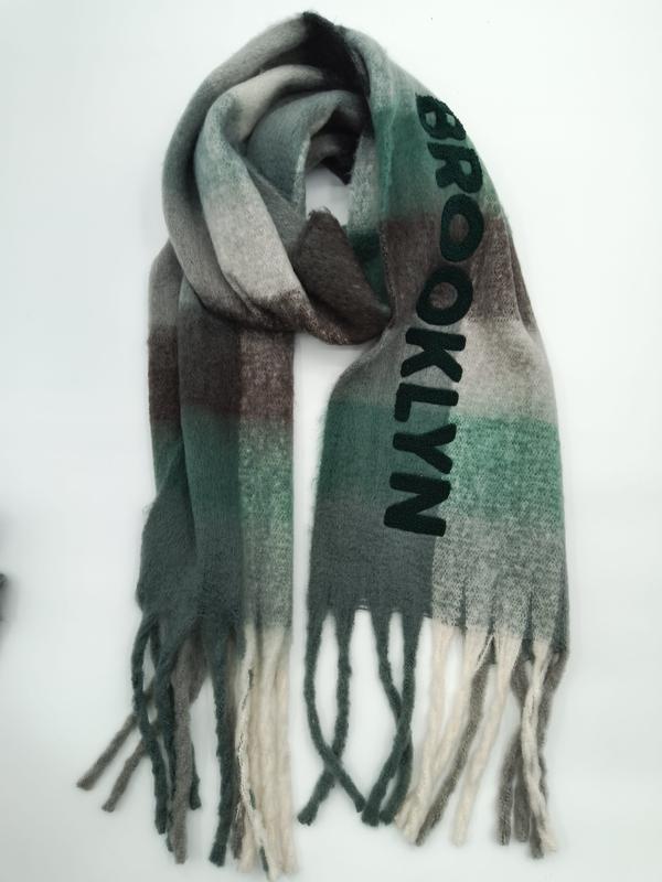 Folded Brooklyn-lettered plaid scarf in green, grey, and brown ombre pattern with twisted fringe ends on white background - boutique retail bulk order