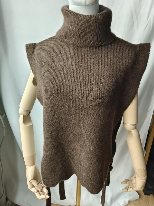 Brown chunky knit sleeveless turtleneck sweater vest with scalloped hem and side tie belt on mannequin - ODM OEM service available - Oeko-Tex Standard 100 certified