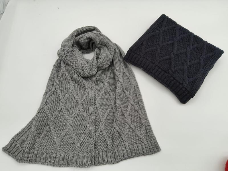 Grey cable knit diamond pattern scarf laid flat beside a folded navy blue cable knit scarf on white background - email us get price list now