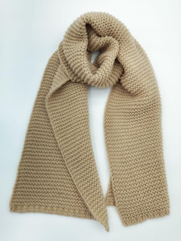 Camel beige chunky knit winter scarf looped and draped flat lay on white background showing textured garter stitch pattern - tiered pricing available ask quote