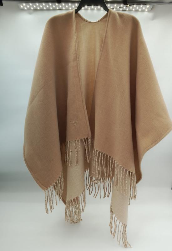Camel beige fringed wrap poncho cape in soft wool blend, open front design with tassel hem, displayed on hanger - contact for custom design quote