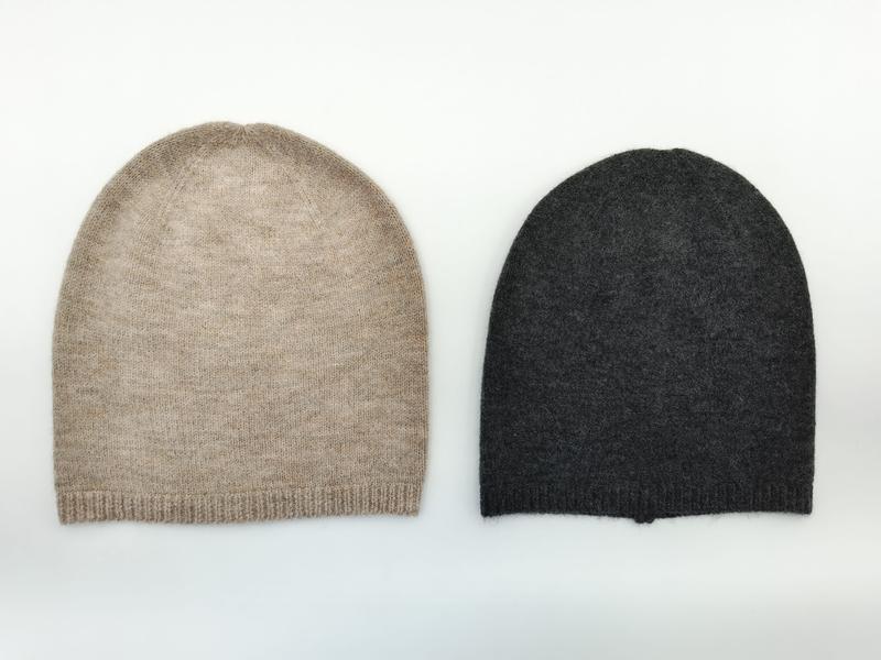Two flat-lay cashmere slouchy beanies side by side, oatmeal beige and charcoal gray, ribbed cuff knit hats on white background - air shipping 5-7 days arrival