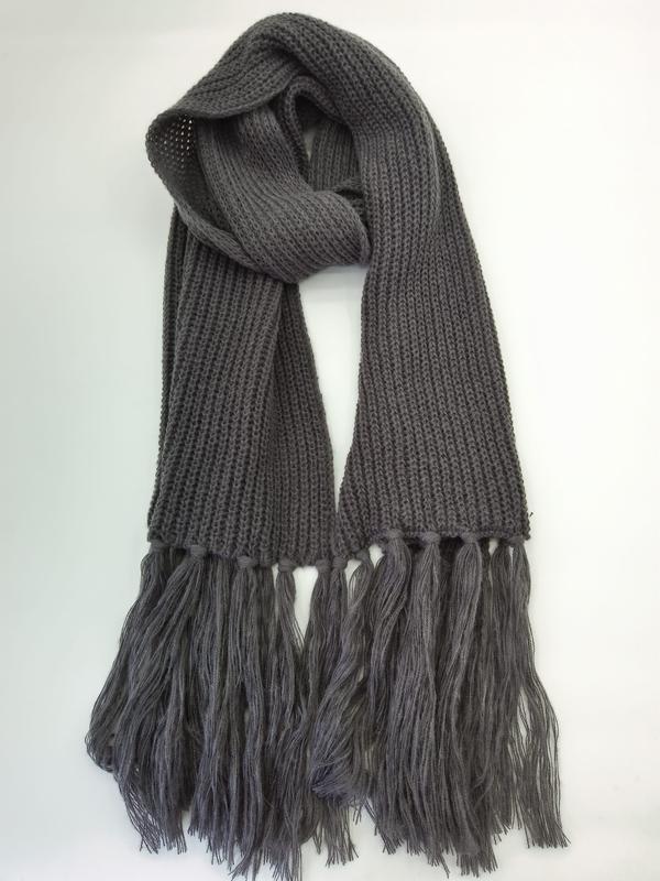 Charcoal gray chunky ribbed knit scarf with long tassel fringe ends, loosely draped on white background - request quote reply same day