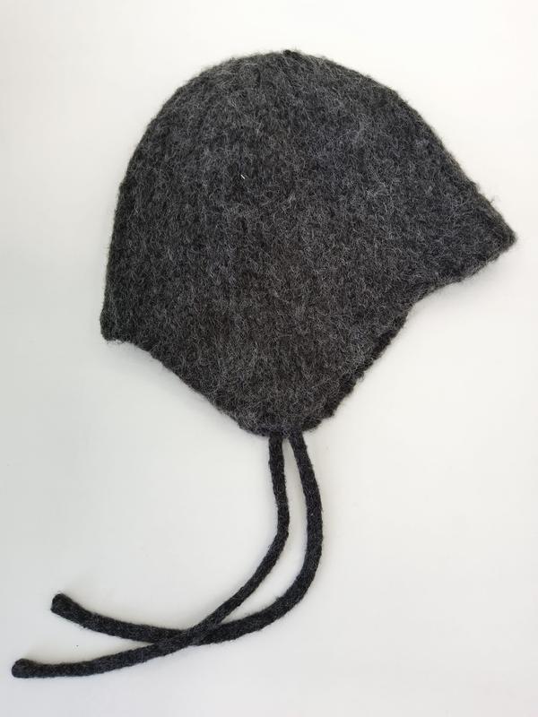 Handknit charcoal gray felted wool baby bonnet with ear flaps and braided tie strings laid flat on white background - MOQ 100pcs mixed colors OK