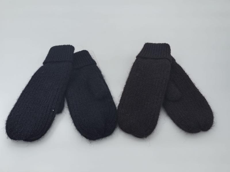 Two pairs of chunky knit mittens in black and dark brown laid flat on white background, showing ribbed cuffs and fluffy texture - corporate gift customization
