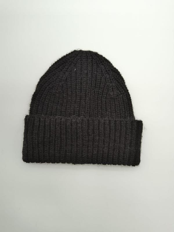 Black chunky ribbed knit beanie hat with folded cuff, laid flat on white background, handcrafted wool blend - ODM OEM service available - hotel amenity scarf supplier