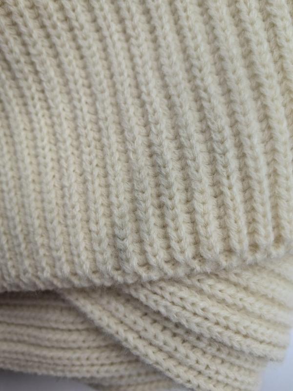 Close-up of a chunky ribbed knit blanket in cream ivory color showing detailed stitch texture and folded layers - MOQ 100pcs mixed colors OK