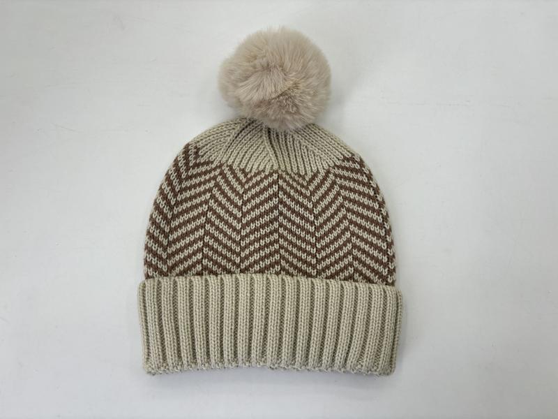 Cream knit beanie hat with brown chevron zigzag pattern and fluffy faux fur pom pom on white background - gift shop wholesale supplier