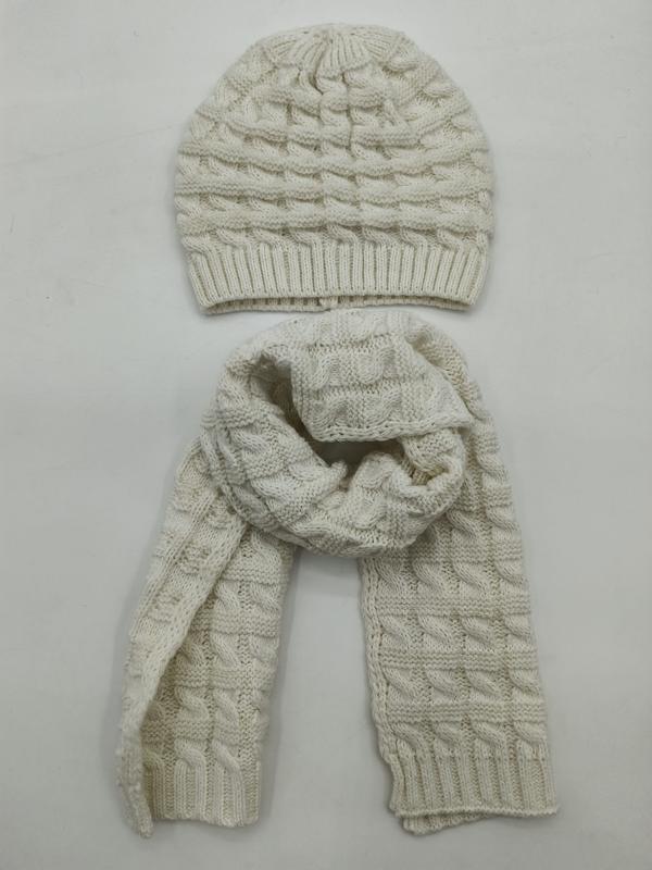 Cream white cable knit beanie hat and matching long scarf set laid flat on white background - hotel amenity scarf supplier