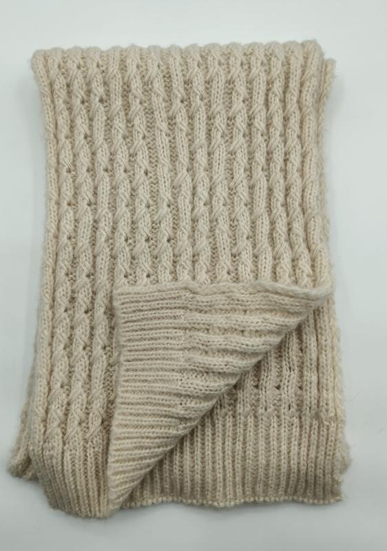 Folded cream cable knit throw blanket with ribbed texture and twisted stitch pattern on white background - winter accessories wholesaler