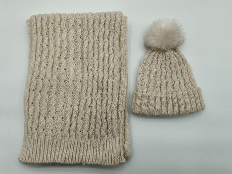 Cream cable knit winter beanie hat with faux fur pom-pom and matching ribbed knit scarf set laid flat - retail buyer inquiry welcome - custom packaging design free