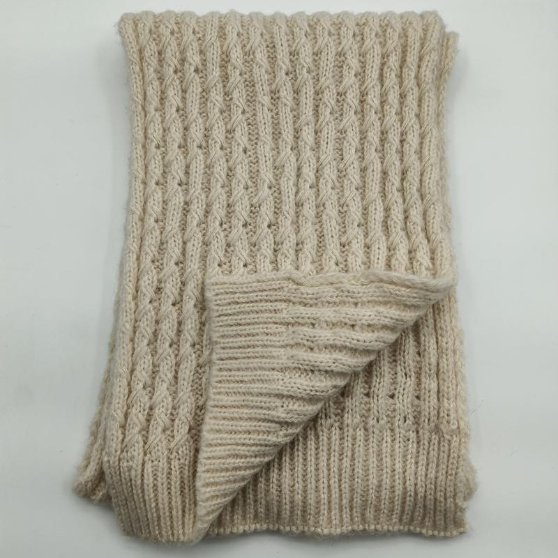Folded cream chunky cable knit throw blanket showing ribbed texture and reverse side on white background - gift shop wholesale supplier