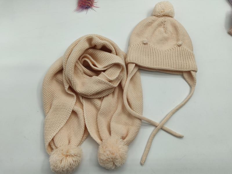 Cream knit children's winter hat with ear flaps and pom pom top paired with matching scarf with pom pom ends - bulk order 20-day delivery