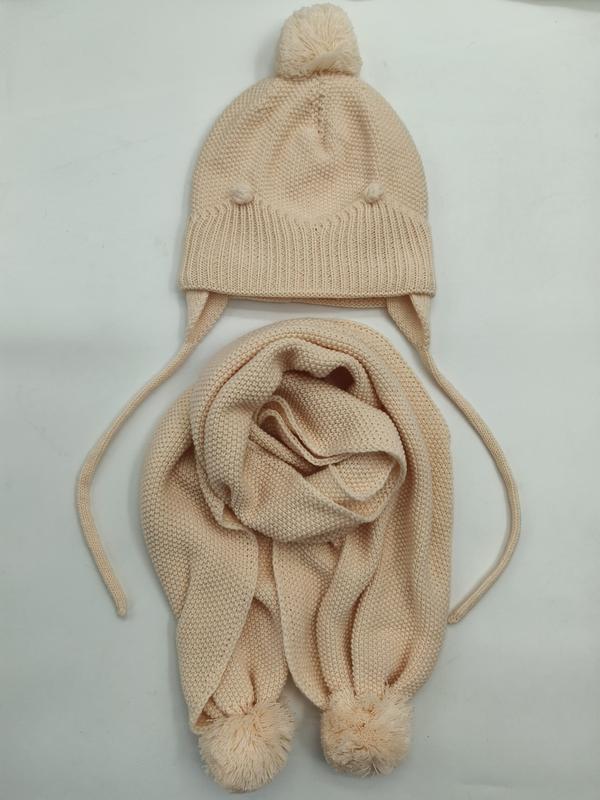 Cream knit children's winter hat with pom-pom top and ear flaps paired with matching knit scarf with pom-pom ends - free sample within 7 days