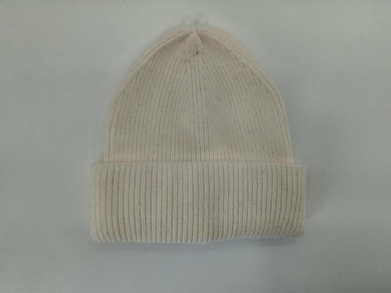Cream off-white ribbed knit beanie hat with folded cuff displayed flat on light gray background - gift shop wholesale supplier