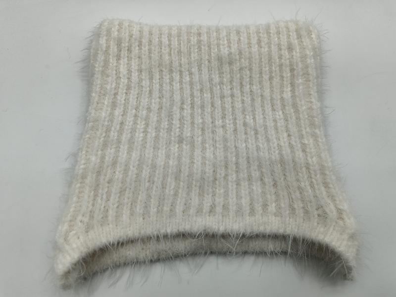 Close-up of a cream and beige ribbed knit fabric swatch with soft mohair halo texture, folded flat on white background - winter accessories wholesaler