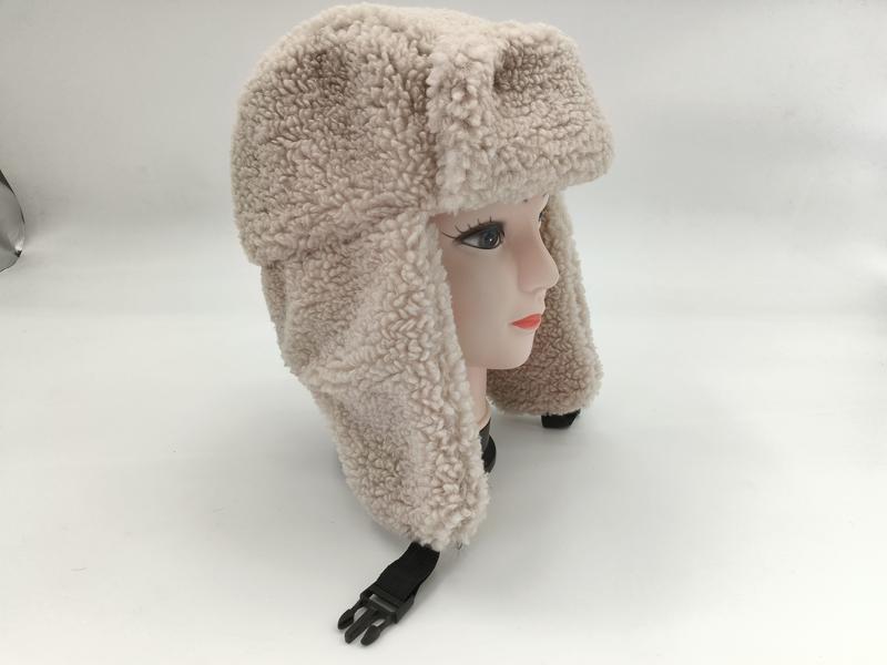 Cream curly sherpa fleece trapper ushanka hat with ear flaps and black plastic buckle chin strap on mannequin head - free sample within 7 days