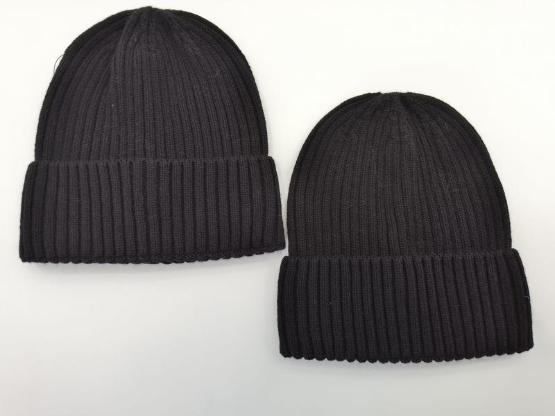Two ribbed knit beanie hats side by side, one dark charcoal and one black, both with folded cuffs on white background - custom Pantone color matching