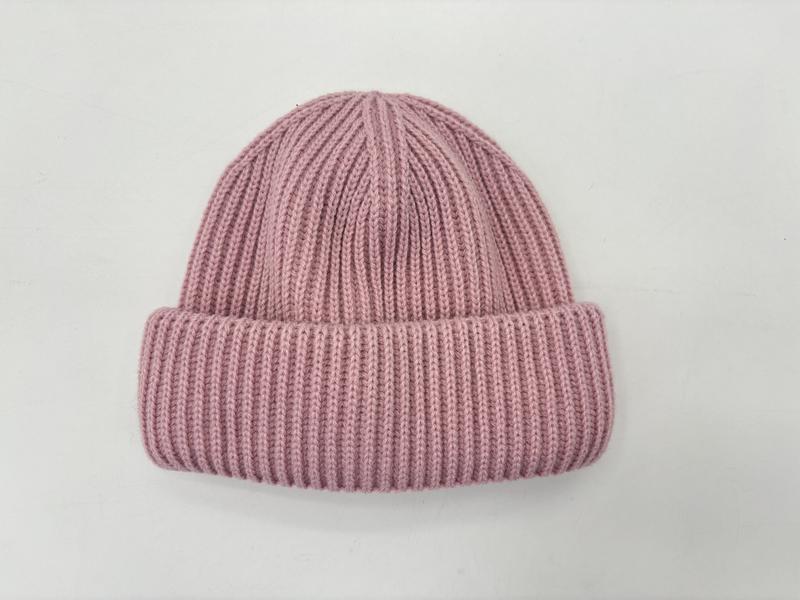 Flat lay of a dusty pink ribbed knit winter beanie hat with a rolled cuff, photographed on a white background - small batch 100pcs accepted