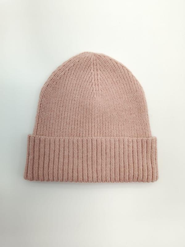 Flat lay of a dusty pink ribbed knit winter beanie hat with a wide folded cuff on a white background - WhatsApp quote in 2 hours