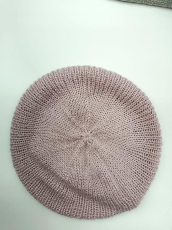 Top view of a dusty rose pink ribbed knit beret hat laid flat on a white surface, showing spiral crown detail - factory direct price no middleman