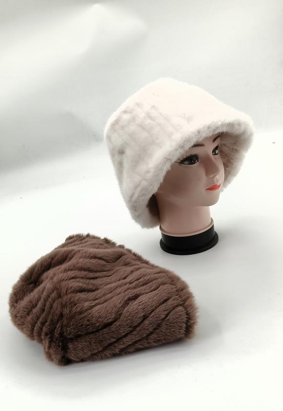 White faux fur bucket hat on mannequin head with brown ribbed plush beanie hat laid flat on white surface - boutique retail bulk order