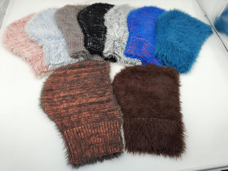 Seven fluffy faux fur and chunky knit beanies in pink, gray, black, white, blue, rust, and brown laid flat on white surface - jacquard custom pattern accepted
