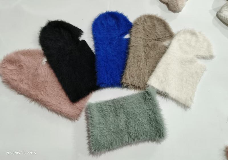 Six fluffy faux fur balaclava hats arranged in a fan layout in pink, black, blue, taupe, cream, and sage green colors - gift shop wholesale supplier