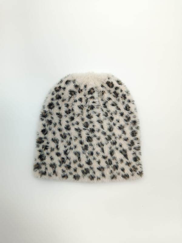 Flat lay of a fluffy ivory beanie hat with black and brown leopard spot print pattern on white background - private label service available