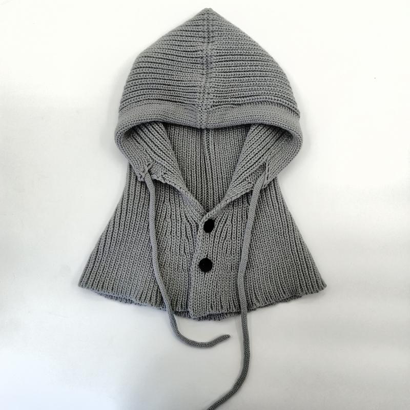 Gray ribbed knit hooded capelet laid flat, featuring two dark buttons, drawstring ties, and a structured hood on white background - bulk order 20-day delivery