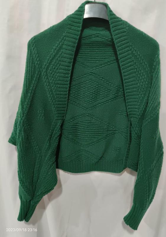 Green chunky knit open front shrug cardigan with diamond cable pattern displayed on hanger, long sleeves with ribbed cuffs - BSCI audit passed supplier