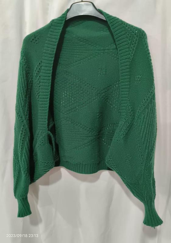 Green open-front knitted cardigan with diamond lace pattern and ribbed cuffs displayed on a hanger against white background - Oeko-Tex Standard 100 certified