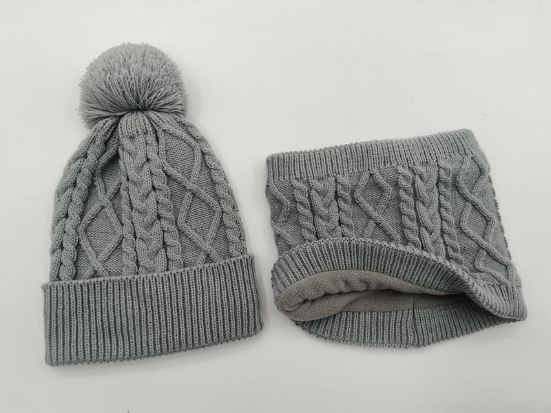Grey cable knit winter beanie hat with pom pom and matching fleece-lined neck gaiter set on white background - corporate gift customization